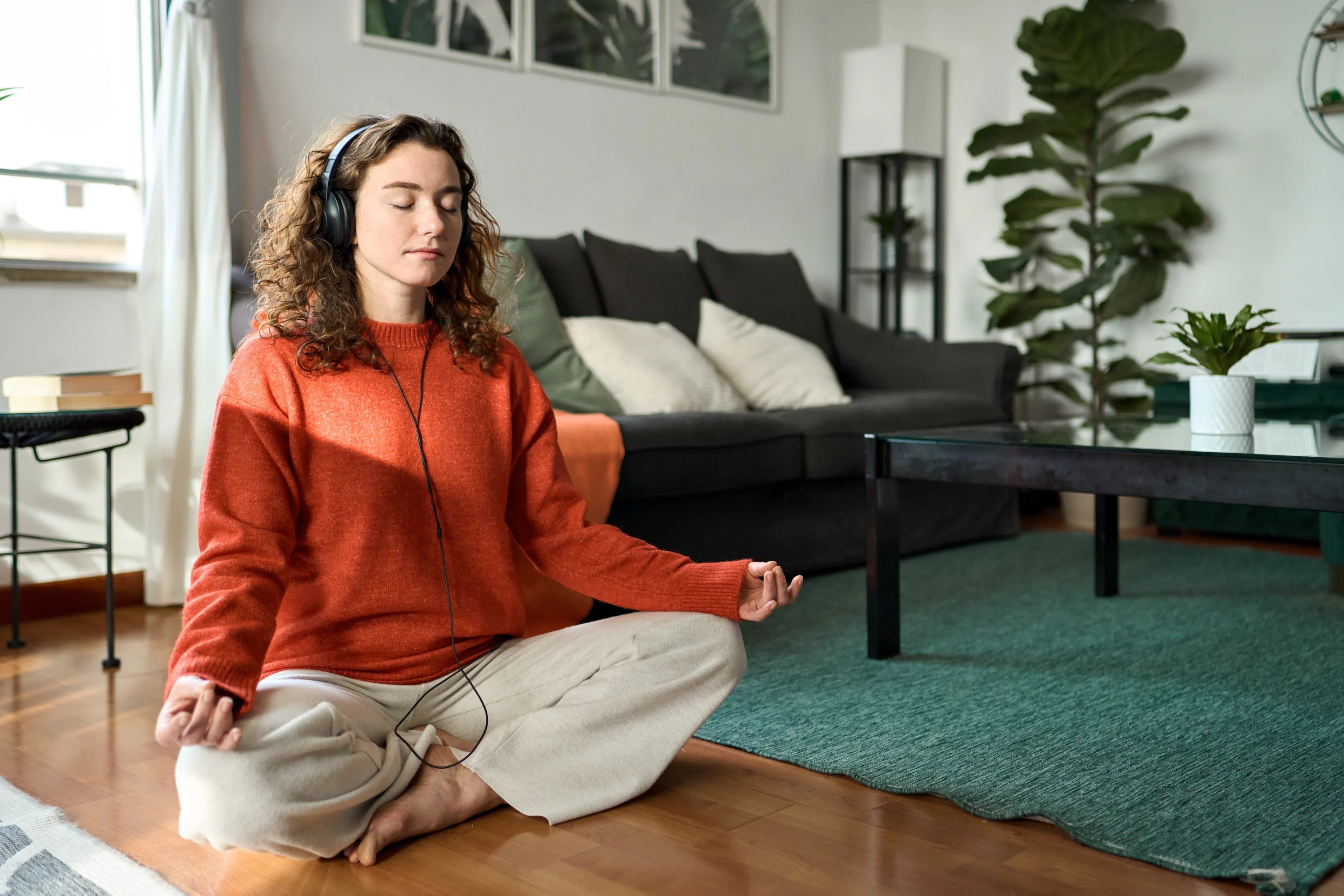 Girl meditating in her living room. 
